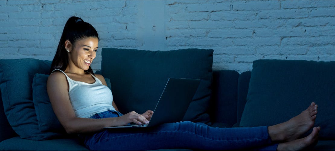 woman enjoying laptop on couch