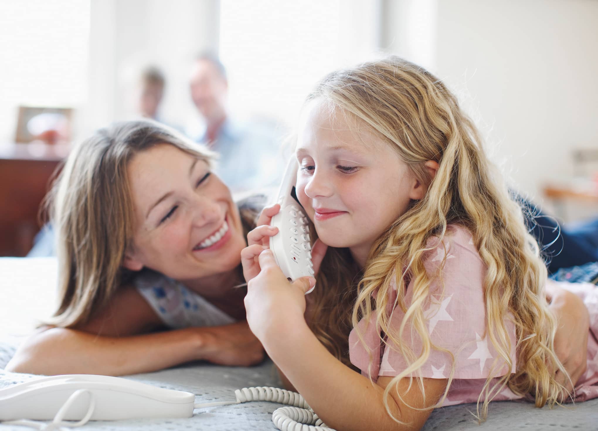 Mother and daughter using home phone